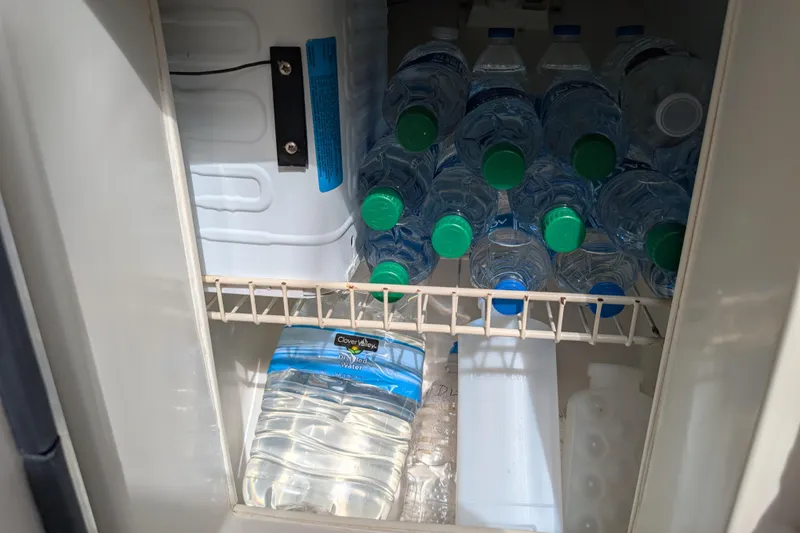 Slide: The Image of Refrigerator stocked with water bottles in a 2004 Catalina 310 boat. - 14