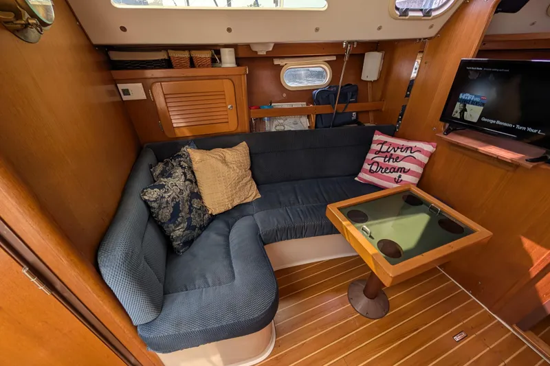 Slide: The Image of Cozy interior of 2004 Catalina 310 sailboat with cushioned seating and wooden accents. - 16