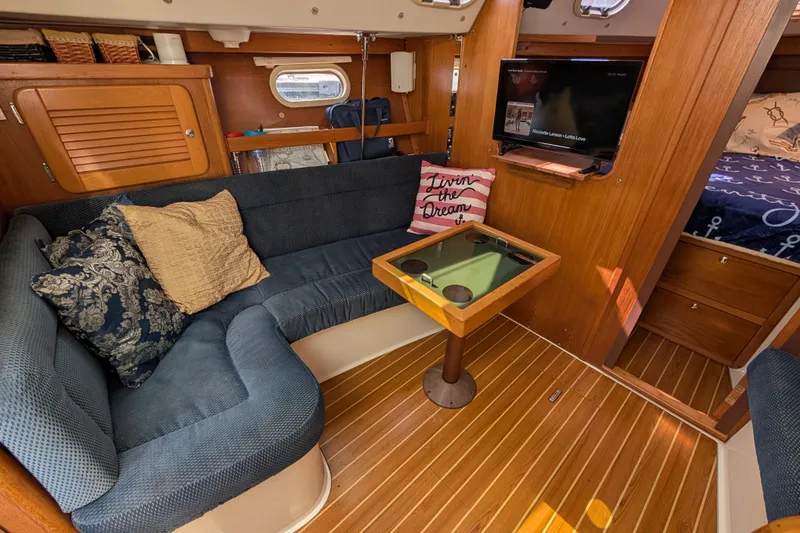 Slide: The Image of Cozy interior of a 2004 Catalina 310 sailboat with seating, table, and TV. - 17