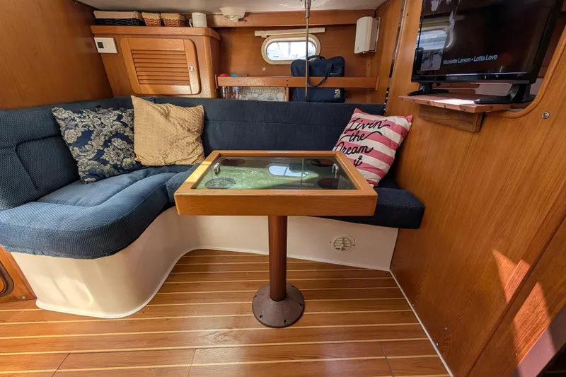 Slide: The Image of Interior of 2004 Catalina 310 sailboat with cozy seating and wooden table. - 18