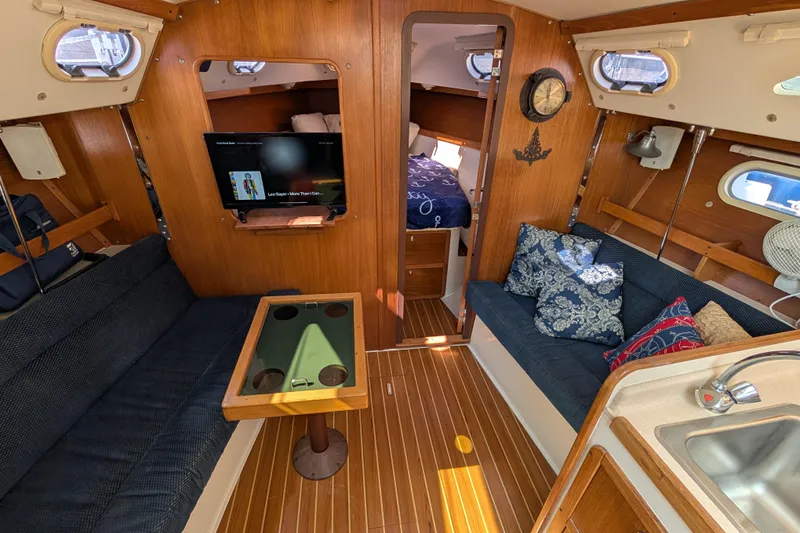 Slide: The Image of Cozy interior of 2004 Catalina 310 sailboat with seating, TV, and nautical decor. - 19