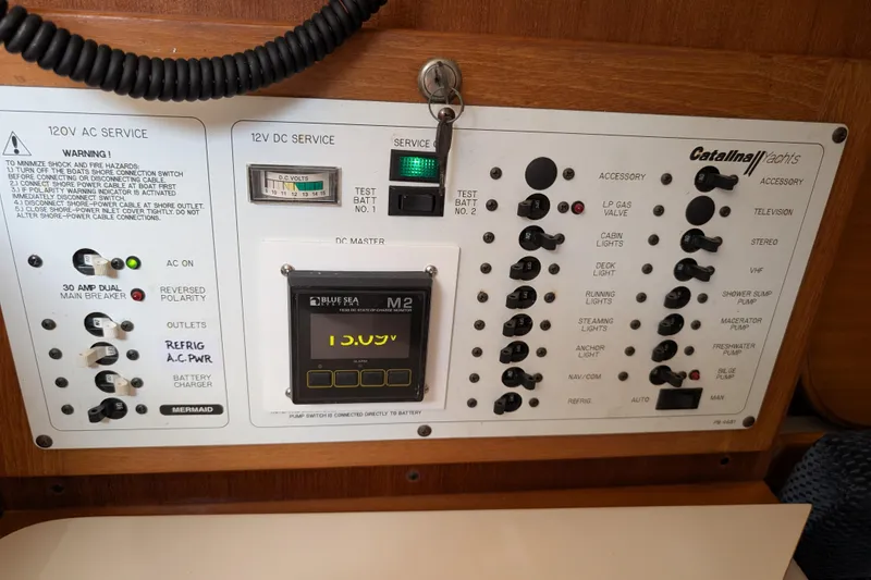Slide: The Image of Electrical control panel of a 2004 Catalina 310 yacht with various switches and indicators. - 20