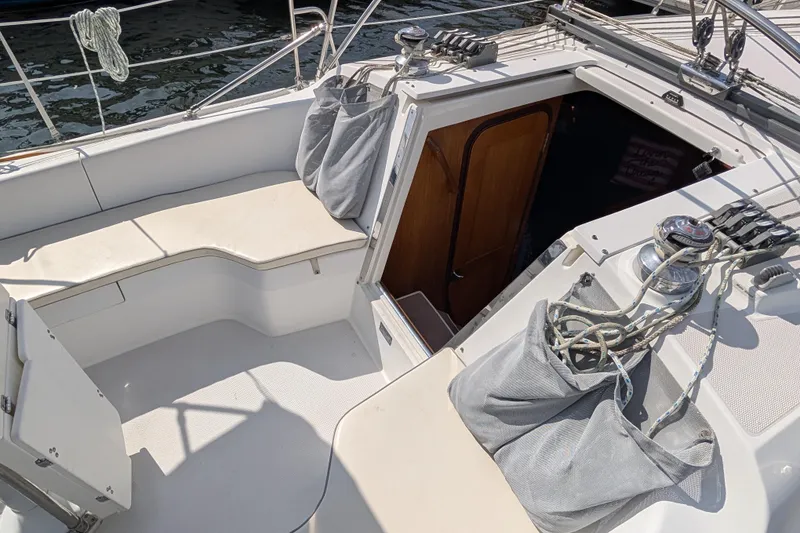 Slide: The Image of 2004 Catalina 310 sailboat cockpit with seating, ropes, and cabin entrance. - 28