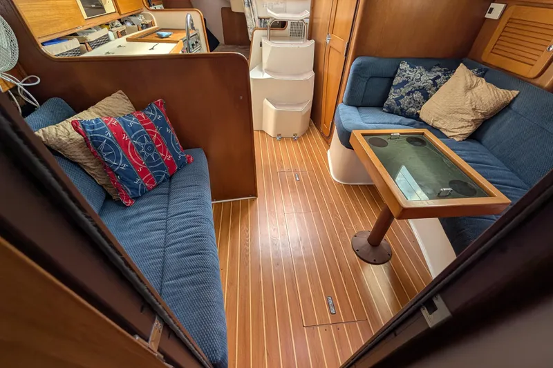 Slide: The Image of Interior of 2004 Catalina 310 sailboat with cozy seating and wooden flooring. - 3