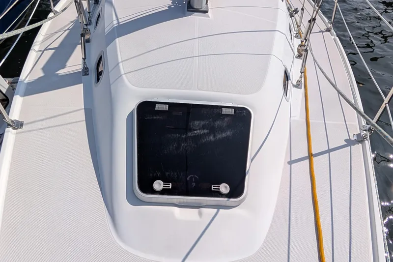 Slide: The Image of 2004 Catalina 310 yacht deck with hatch, surrounded by safety railings. - 36