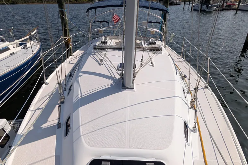 Slide: The Image of 2004 Catalina 310 sailboat deck view at marina, featuring rigging and American flag. - 37