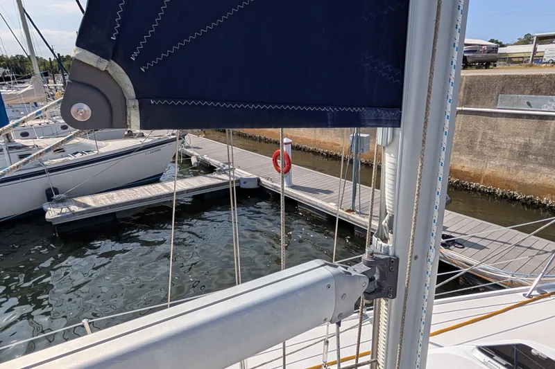 Slide: The Image of Sailboat docked at marina, featuring Catalina 310, 2004 model, with visible rigging and sail. - 42