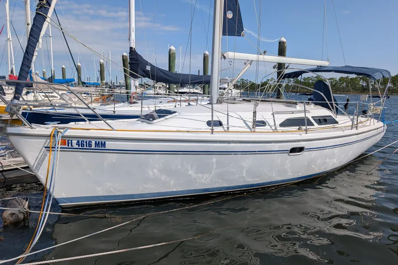Slide: The Image of 2004 Catalina 310 sailboat docked at marina, clear sky, calm water. - 49