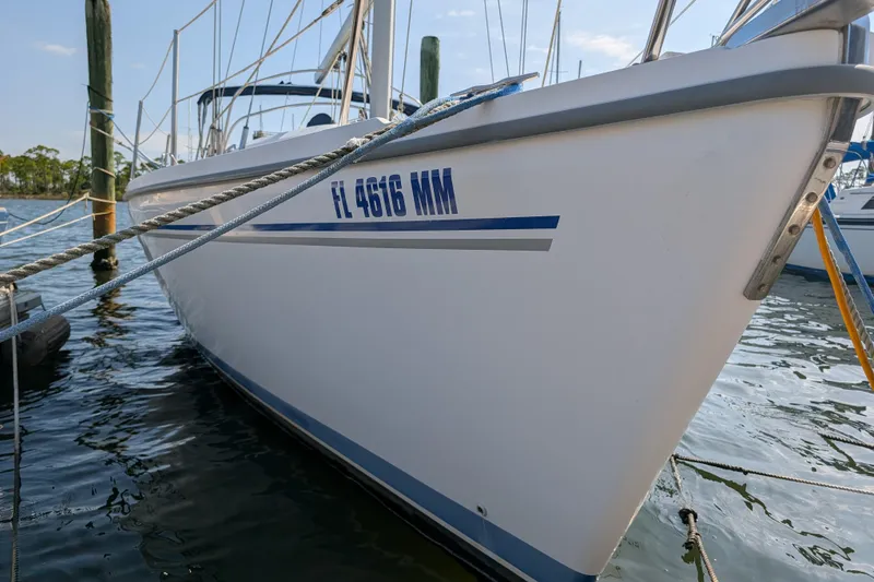 Slide: The Image of 2004 Catalina 310 sailboat docked, displaying registration FL 4616 MM. - 50