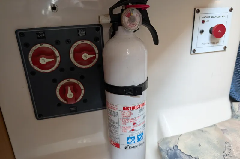 Slide: The Image of Fire extinguisher and control panel inside 2004 Catalina 310 boat cabin. - 53