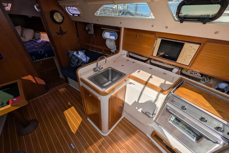 Slide: The Image of Interior of 2004 Catalina 310 sailboat with kitchen, sink, and wooden cabinetry. - 7