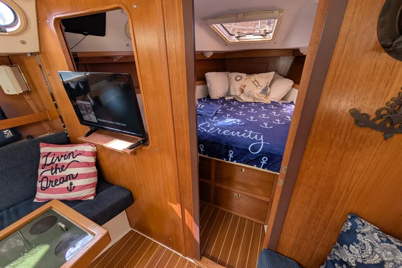 Slide: The Image of Cozy interior of 2004 Catalina 310 sailboat with bed, TV, and nautical decor. - 8