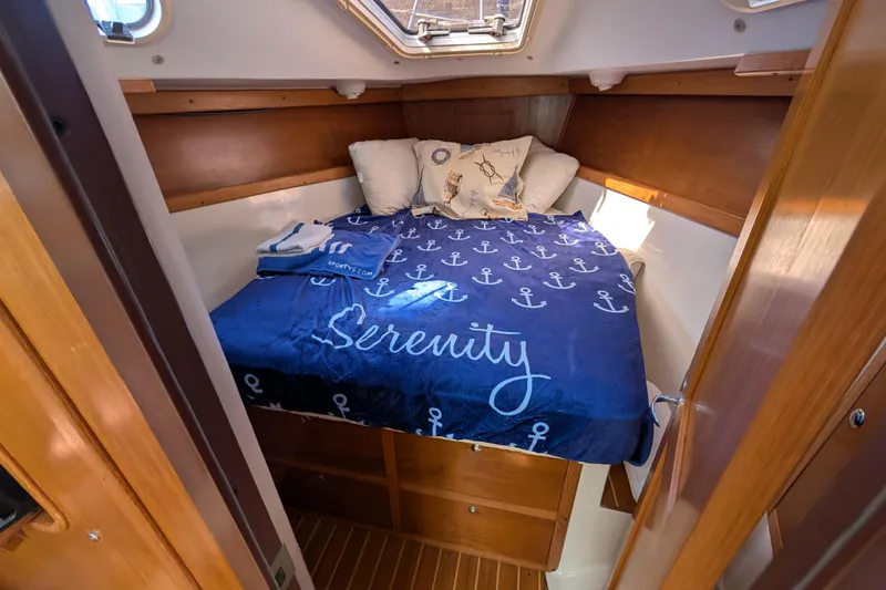 Slide: The Image of Cozy cabin interior of 2004 Catalina 310 sailboat with nautical-themed bedding. - 9