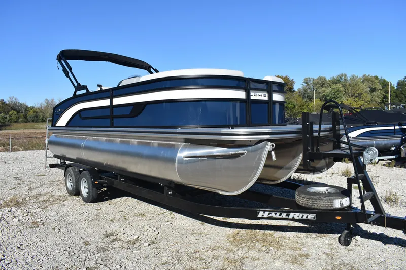 Slide: The Image of 2026 Lowe SS 230 DV pontoon boat on trailer, parked outdoors under clear blue sky. - 3