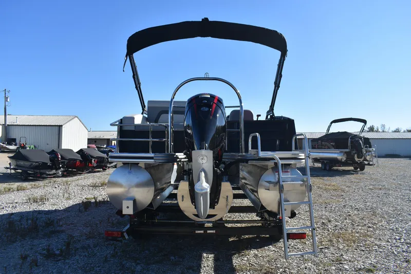 Slide: The Image of 2026 Lowe SS 230 DV pontoon boat with outboard motor and ladder, parked outdoors. - 5