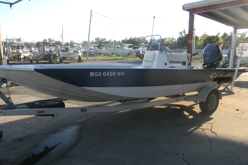 The Image of 2017 G3 Bay 20 DLX boat on trailer, parked outdoors in a marina setting. - 0