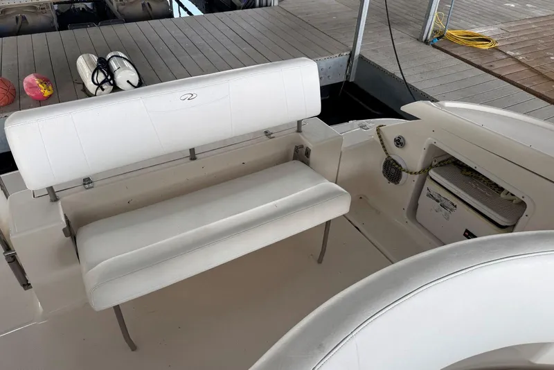 Slide: The Image of 2005 Regal 3360 Window Express boat interior with white seating and dock view. - 10