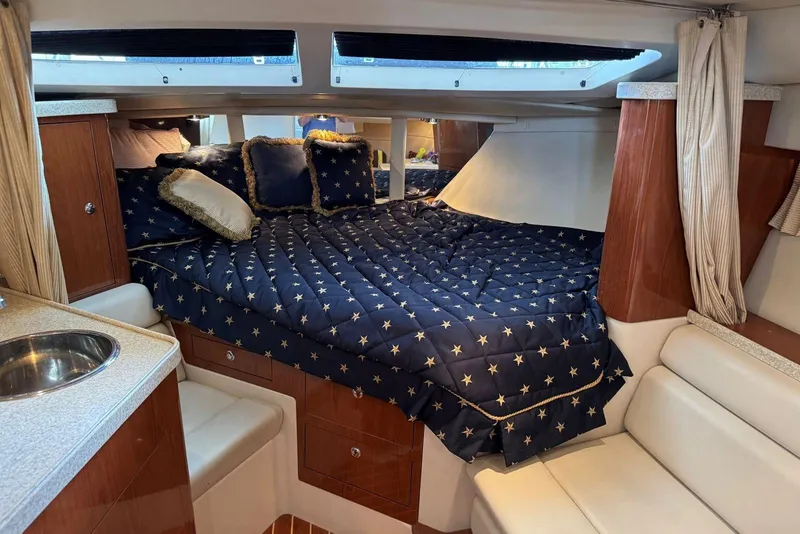 Slide: The Image of Luxurious cabin interior of 2005 Regal 3360 Window Express yacht with star-patterned bedding. - 26