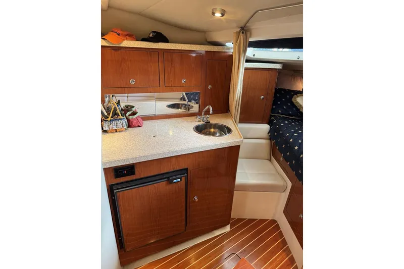 Slide: The Image of 2005 Regal 3360 Window Express yacht interior with kitchenette and cozy seating area. - 27