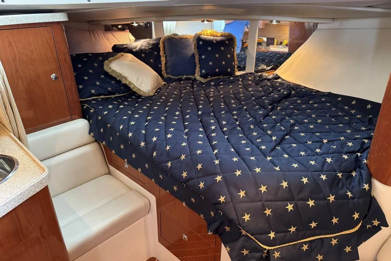 Slide: The Image of Luxurious cabin interior of 2005 Regal 3360 Window Express with star-patterned bedding. - 28