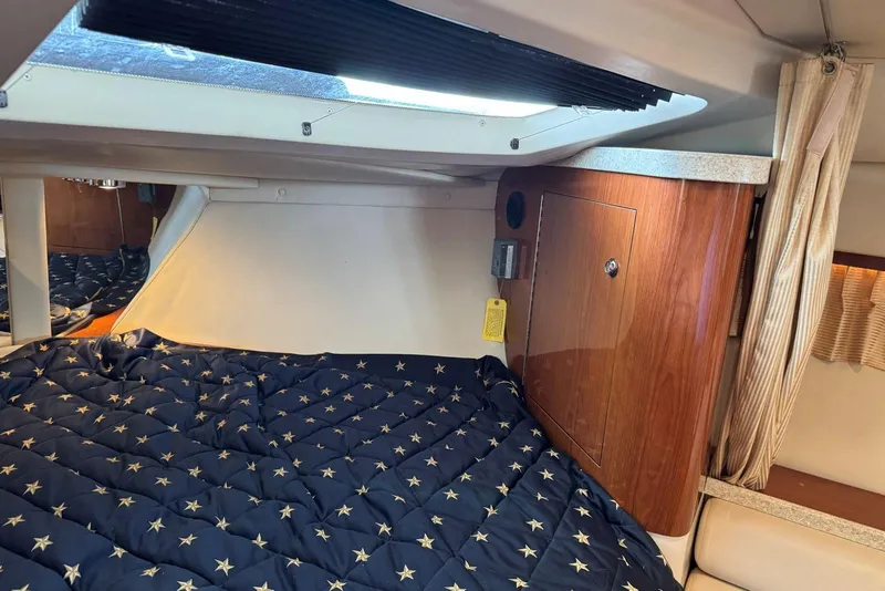 Slide: The Image of 2005 Regal 3360 Window Express cabin interior with star-patterned bedding and wooden cabinetry. - 29
