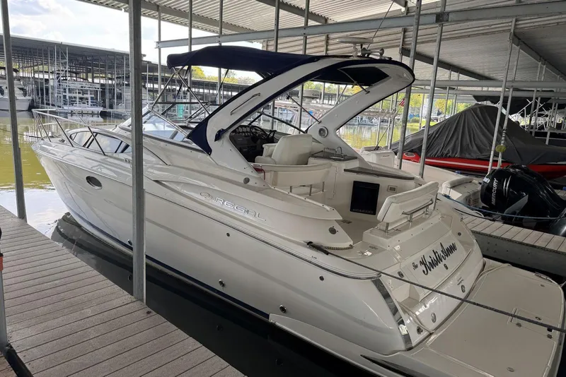 Slide: The Image of 2005 Regal 3360 Window Express boat docked in a marina under a covered shelter. - 4