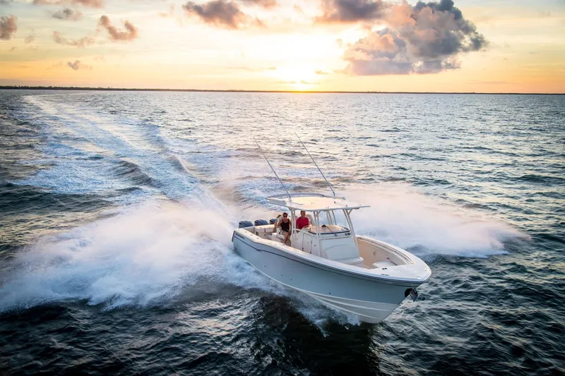 Slide: The Image of 2010 Grady-White Canyon 336 boat with dual outboard engines, docked by the water. - 18