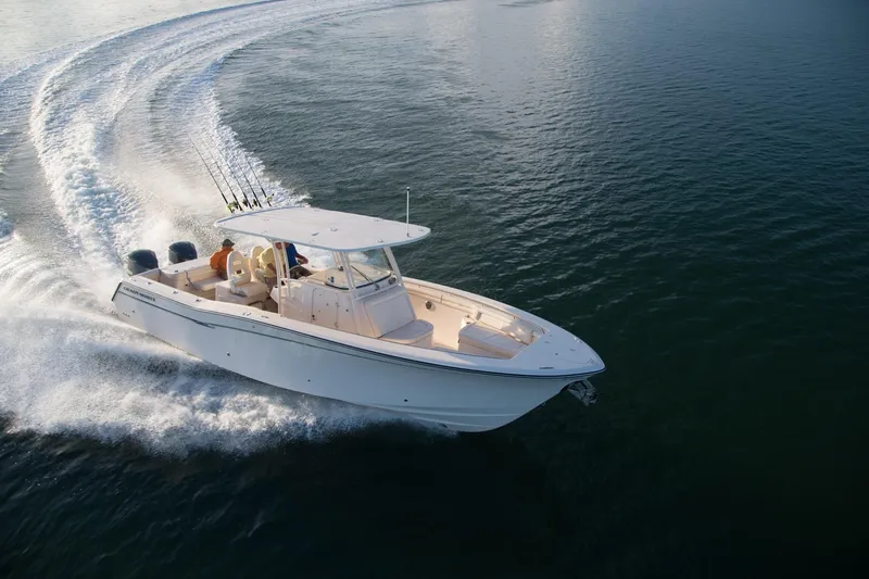 Slide: The Image of 2010 Grady-White Canyon 336 boat interior with steering console, docked near high-rise buildings. - 27