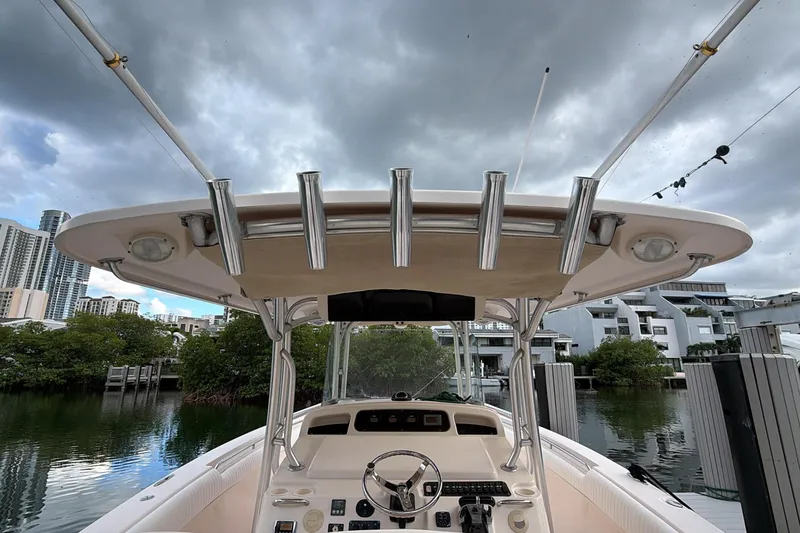 Slide: The Image of 2010 Grady-White Canyon 336 boat helm with steering wheel and controls, docked by water. - 29