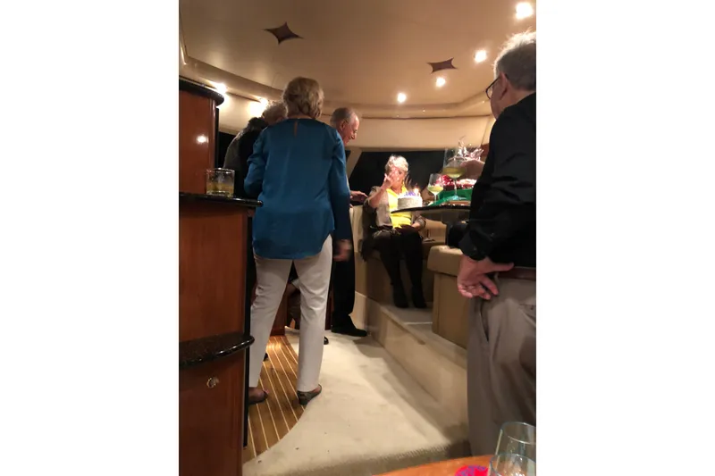Slide: The Image of People socializing inside a 2007 Meridian 411SB yacht, enjoying drinks and conversation. - 14