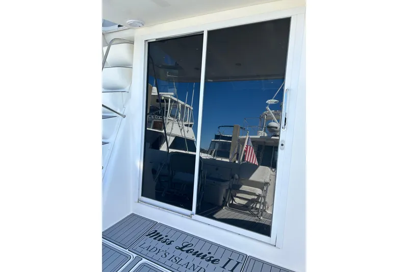 Slide: The Image of 2007 Meridian 411SB yacht with reflective glass door and visible American flag. - 26
