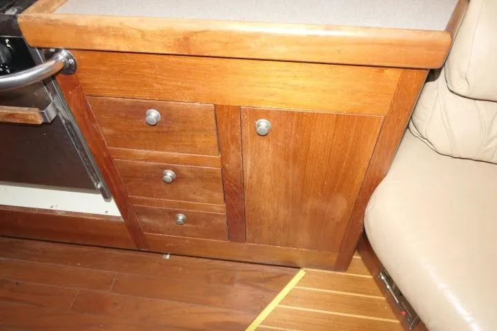 Slide: The Image of Wooden cabinetry in a 1999 Hunter 450 Passage yacht interior, featuring drawers and a cabinet door. - 20