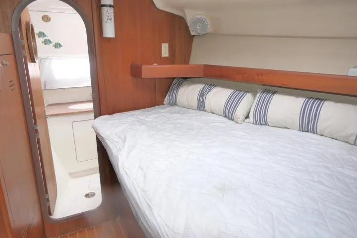 Slide: The Image of Cozy cabin interior of 1999 Hunter 450 Passage sailboat with striped pillows and wooden accents. - 25