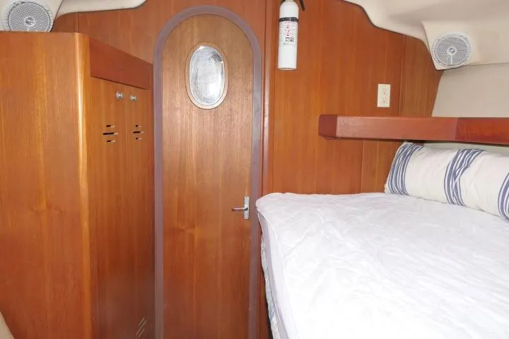 Slide: The Image of Cozy cabin interior of 1999 Hunter 450 Passage sailboat with wooden finish and bedding. - 26