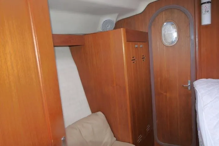 Slide: The Image of Interior of 1999 Hunter 450 Passage yacht with wooden cabinetry and porthole door. - 27