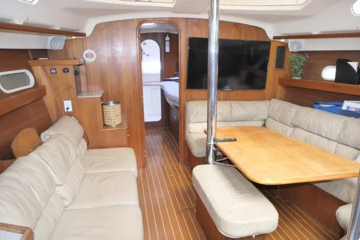 Slide: The Image of Interior of 1999 Hunter 450 Passage yacht with wood paneling and beige seating. - 3