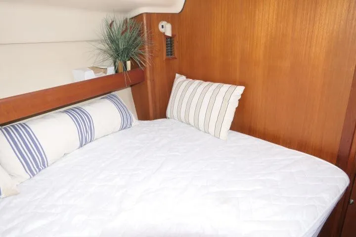 Slide: The Image of Cozy cabin interior of 1999 Hunter 450 Passage yacht with striped pillows. - 30