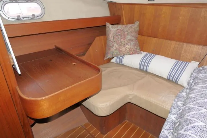 Slide: The Image of Cozy cabin interior of 1999 Hunter 450 Passage sailboat with wooden accents and cushions. - 38