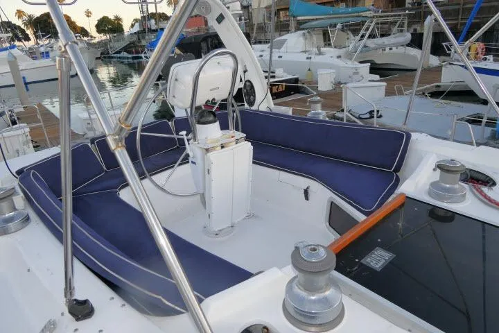 Slide: The Image of Cockpit of 1999 Hunter 450 Passage sailboat with blue cushioned seating and steering wheel. - 46