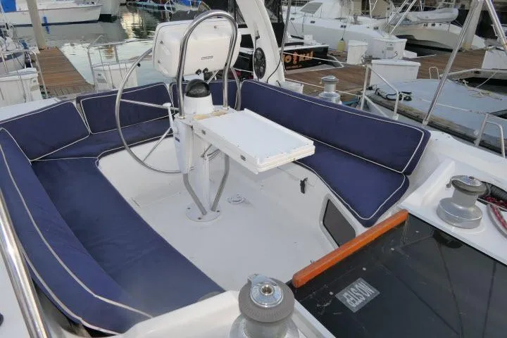 Slide: The Image of Cockpit of 1999 Hunter 450 Passage sailboat with blue cushioned seating and steering wheel. - 47
