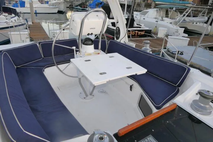 Slide: The Image of Cockpit of 1999 Hunter 450 Passage sailboat with blue cushioned seating and steering wheel. - 48