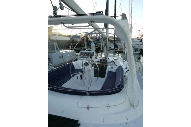 Slide: The Image of 1999 Hunter 450 Passage sailboat cockpit with steering wheel, docked at marina. - 49
