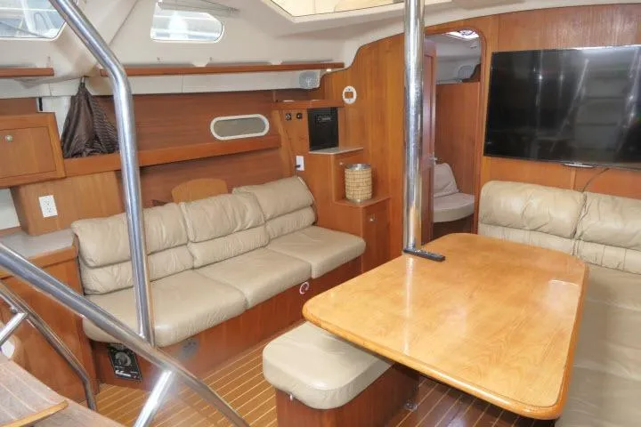 Slide: The Image of Interior of 1999 Hunter 450 Passage yacht with wood finish and beige seating. - 5