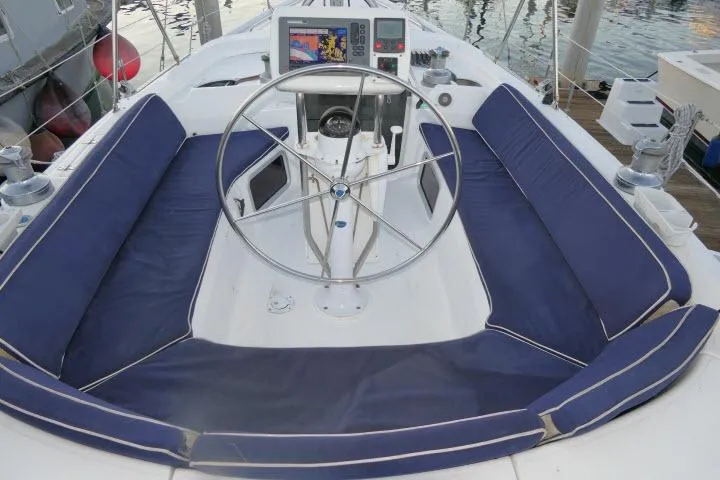 Slide: The Image of Cockpit of 1999 Hunter 450 Passage sailboat with blue cushioned seating and steering wheel. - 51