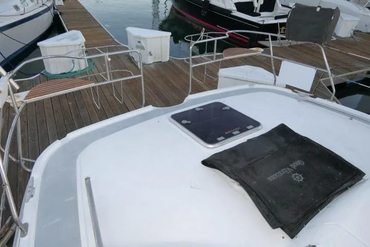 Slide: The Image of 1999 Hunter 450 Passage yacht docked, showing deck and railing details. - 57
