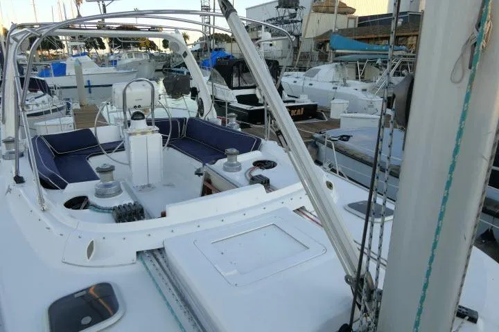 Slide: The Image of Hunter 450 Passage 1999 sailboat docked at marina, featuring spacious cockpit and seating area. - 59