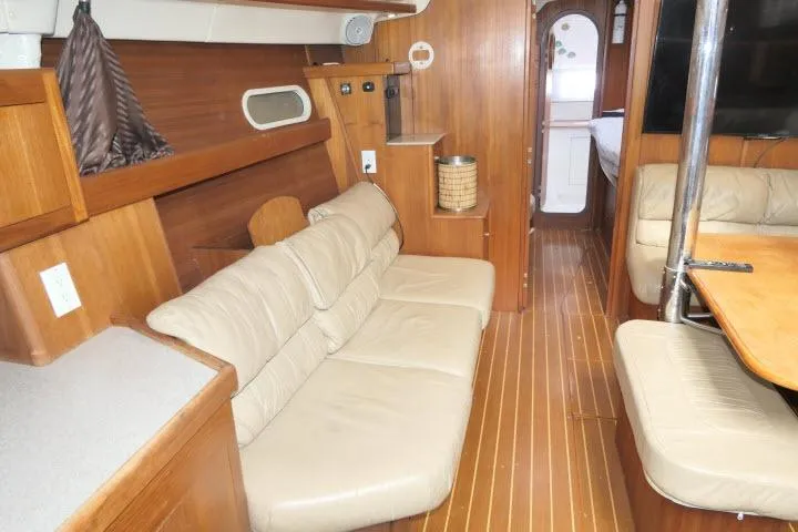 Slide: The Image of Interior of 1999 Hunter 450 Passage yacht with wooden finish and beige seating. - 6