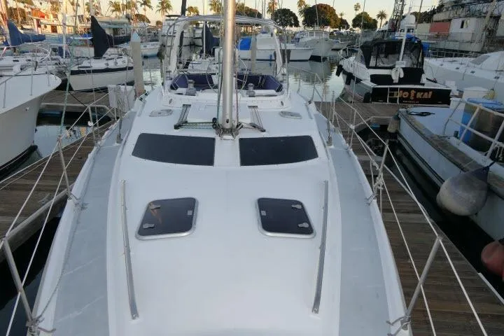 Slide: The Image of 1999 Hunter 450 Passage sailboat docked in a marina, surrounded by other boats. - 63