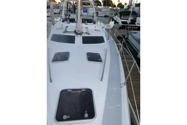 Slide: The Image of 1999 Hunter 450 Passage sailboat docked at marina, showcasing deck and hatches. - 64