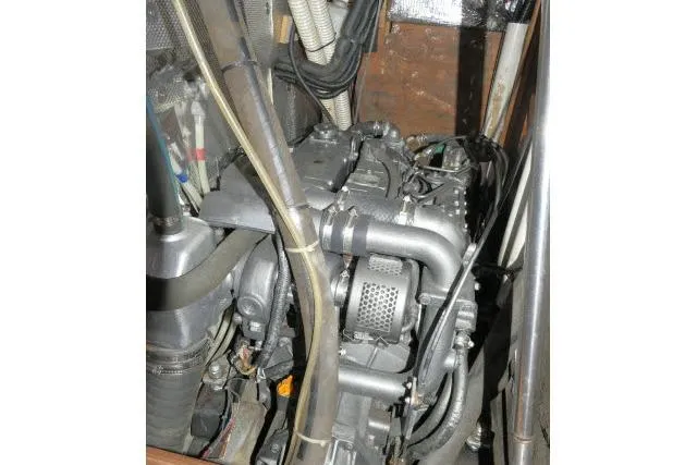 Slide: The Image of Engine compartment of a 1999 Hunter 450 Passage sailboat, showcasing mechanical components and hoses. - 66